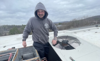 A technician putting a cover back on a heating unit.