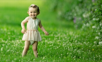 A baby standing outside in nice clean air.