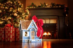 dollhouse-with-red-ribbon-under-christmas-tree-fireplace-in-background