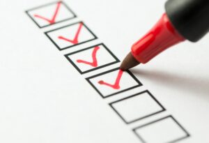 red-pen-checking-off-items-on-blank-checklist