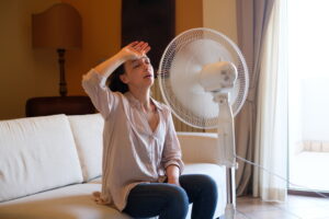 Woman feeling hot and trying to refresh in summertime heat