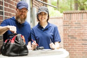 two-technicians-work-on-condenser-outside